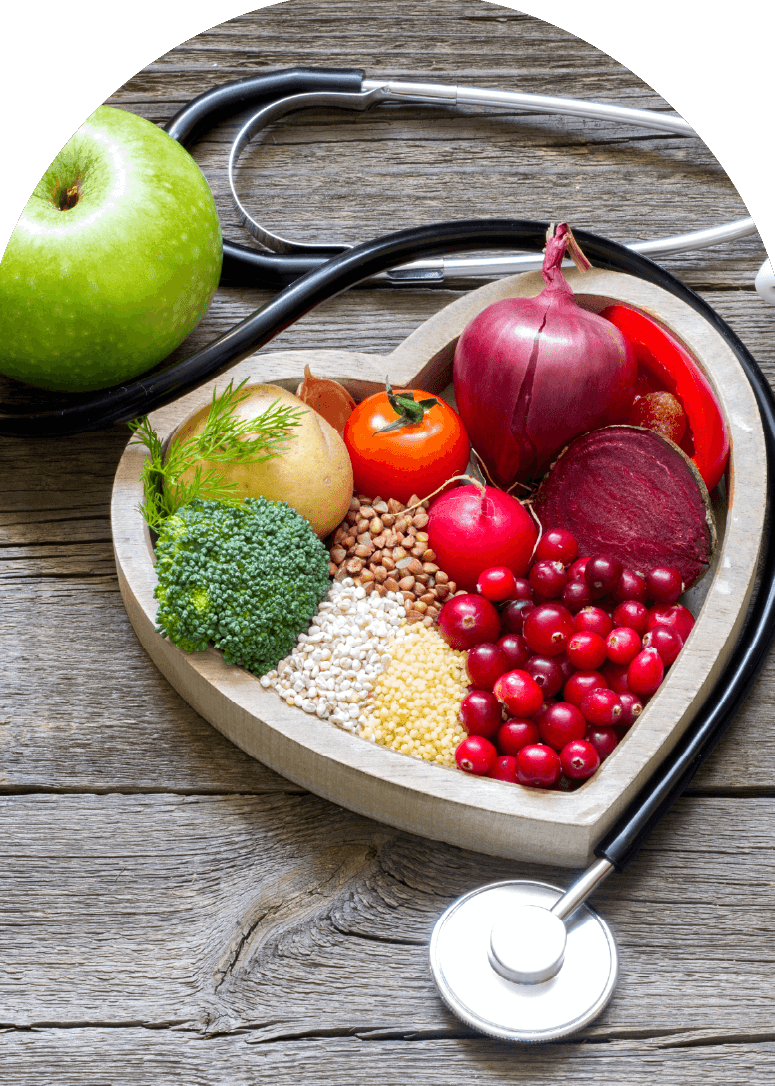 Heart-shaped bowl with fruits, vegetables, and grains beside a stethoscope, symbolizing healthy nutrition and dietetics in healthcare.