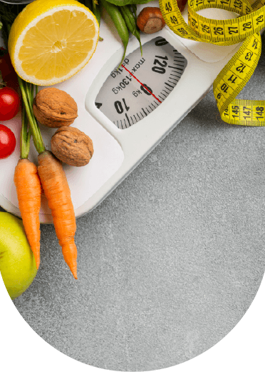Fresh fruits and vegetables with a weighing scale and measuring tape symbolizing nutrition research, dietetics education, and healthy lifestyle management.